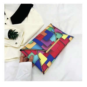 Close-up of geometric color block envelope clutch bag with elegant gold metal trim detail