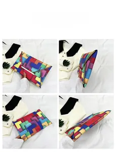 Detail view of colorful geometric pattern clutch with metal bar closure from four angles
