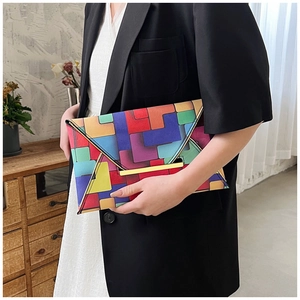 Close-up of geometric color block patterns and gold metal closure on envelope clutch