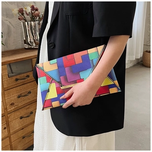 Detail of colorful geometric patchwork clutch bag with stylish gold metal trim and texture