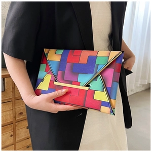 Detail of colorful geometric block pattern on envelope clutch with gold metal bar