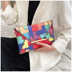 Detail of colorful geometric block pattern on an envelope clutch bag with metal trim