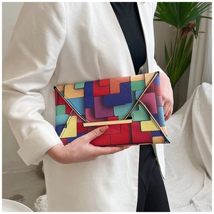 Detail of colorful geometric pattern envelope clutch with elegant gold metal trim