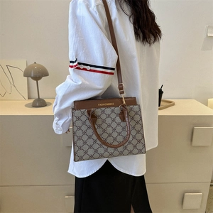 Retro monogrammed tote bag with brown leather trim and clover pattern for daily styling