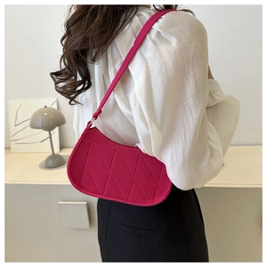 Detail of fuchsia underarm bag with triangular quilting and slim shoulder strap