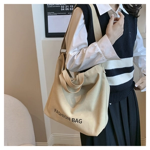 Close-up of beige canvas tote bag with Fashion Bag text and adjustable wide strap