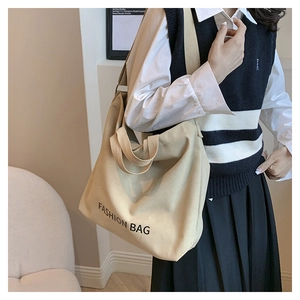 Khaki canvas tote bag with fashion bag lettering shown on shoulder for daily commute