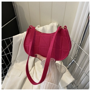 Detailed view of magenta quilted fabric shoulder bag with triangle stitching and zip closure