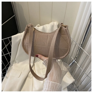 Detail of camel shoulder bag featuring geometric quilting and sleek metal zipper closure