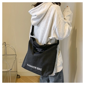 Detail of a black canvas tote with Fashion Bag print and adjustable shoulder strap