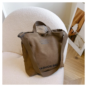 Close-up of brown canvas tote bag with fashion print on a cozy white fleece chair