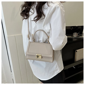 Detail of apricot crossbody bag with crocodile embossed flap and twist handle for women