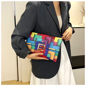 Dettaglio di una pochette geometrica patchwork colorata con fibbia metallica dorata