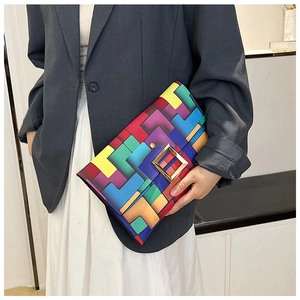 Dettaglio ravvicinato di una borsa a mano con motivi geometrici colorati e fibbia d'oro
