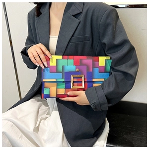 Dettaglio di pochette con motivo geometrico colorato e grande fibbia in metallo dorato