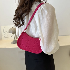 Magenta quilted shoulder bag with geometric triangle pattern worn by a model