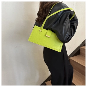 Dettaglio della borsa a tracolla verde neon effetto coccodrillo con fibbia metallica