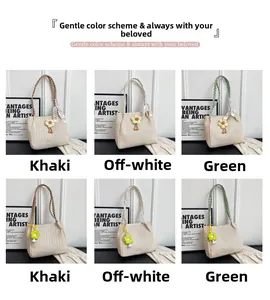 Detail of woven straw shoulder bags in khaki, beige and green with floral charms