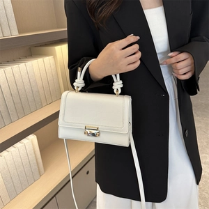 White crocodile-embossed mini crossbody bag with rope handle and gold buckle detail
