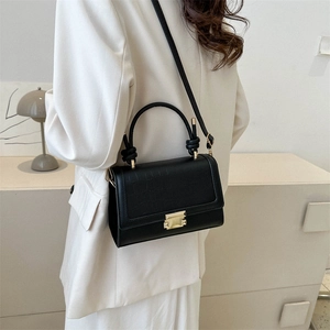 Retro black crossbody bag with crocodile texture and gold buckle shown on a model