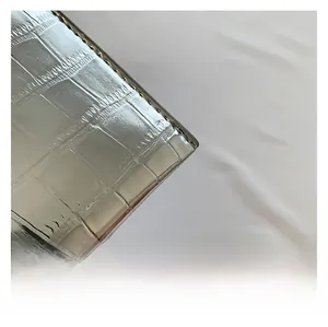 Macro view of silver crocodile pattern texture on metallic finish fashion handbag