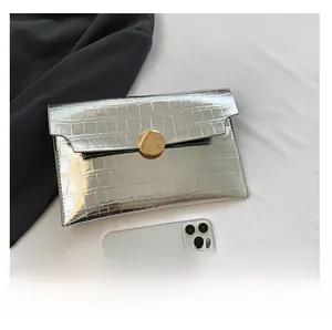 Silver crocodile pattern clutch bag size comparison with a white smartphone