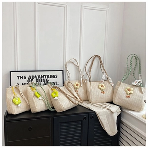 Row of woven tote bags with flower pendants and patterned silk scarves on a shelf