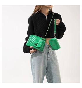 Detailansicht des neongrünen 3-teiligen Taschen-Sets mit V-Steppung und goldener Kette
