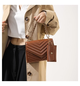 Detail der dunkelbraunen Stepptasche mit abnehmbarem Etui und goldener Metallkette