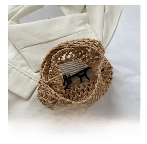 Top view of khaki woven bucket bag showing spacious interior for phone and glasses