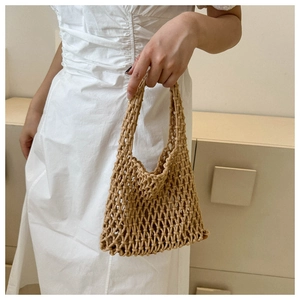 Detail of hand-woven khaki tote bag with intricate hollow-out texture for summer styling