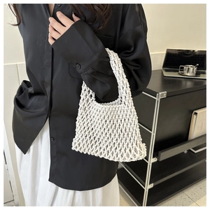 Detail view of cream woven tote bag showing intricate hollow diamond mesh texture