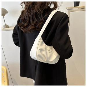 Détail du sac hobo blanc crème avec plaque logo et texture en cuir plissé élégante et douce