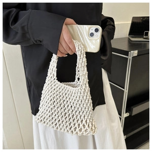 Close-up of white macrame handmade woven mini handbag with thick cotton rope texture