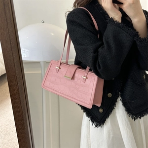 Pink crocodile pattern baguette shoulder bag with gold buckle shown in a mirror selfie