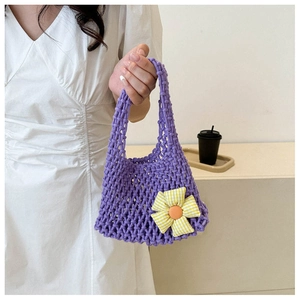 Close-up of hand-woven purple crochet tote bag featuring decorative knit floral patterns