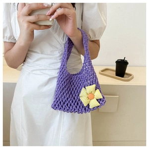 Close-up of purple woven handbag featuring a yellow and white floral daisy decoration