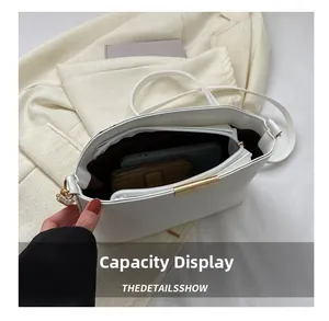 Interior view showing the capacity of a white leather shoulder bag with a brown lining