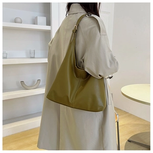Detail of olive green leather tote bag with vertical stitching and adjustable strap