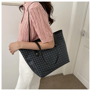 Fashionable tote bag with blue dots on black, styled with pink polo shirt for commute