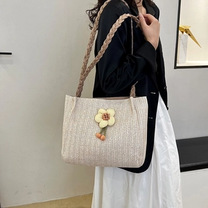 Retro woven shoulder bag in beige featuring floral charms and brown leather straps