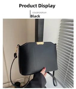 Detail of black faux leather crossbody bag with decorative gold metal hardware accents