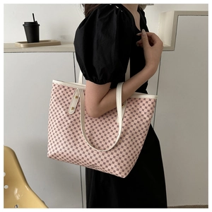 Detailed view of the large tote bag featuring geometric patterns and white leather handles
