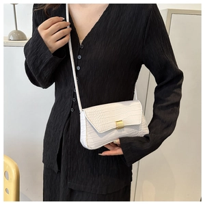 Close-up of white crocodile pattern crossbody bag with a golden metal lock buckle