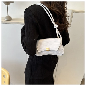 Detail of white crocodile pattern shoulder bag with elegant gold metal buckle closure