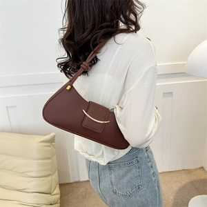 Fashionable dark coffee half-moon shoulder bag with golden crescent buckle on model