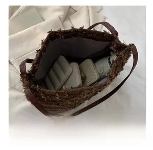 Intérieur spacieux d'un sac cabas marron montrant le rangement du téléphone et parapluie