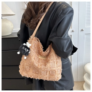 Détail du sac seau en tweed caramel avec franges et charmant porte-clés monstre