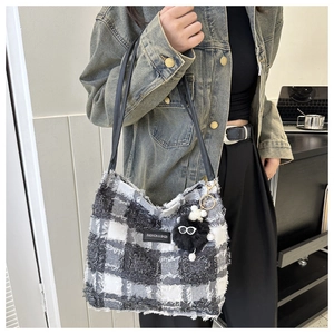 Détail du grand sac cabas à carreaux avec breloque monstre en peluche et étiquette