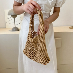 Minimalist khaki woven handbag with hollow mesh design shown held by a model in lifestyle setting